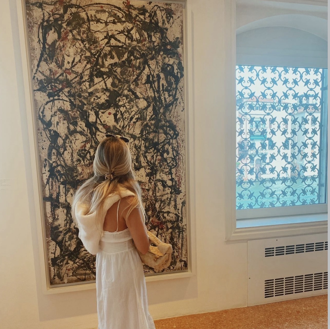 Paloma before a large drip painting in Venice, the Grand Canal through an arched window